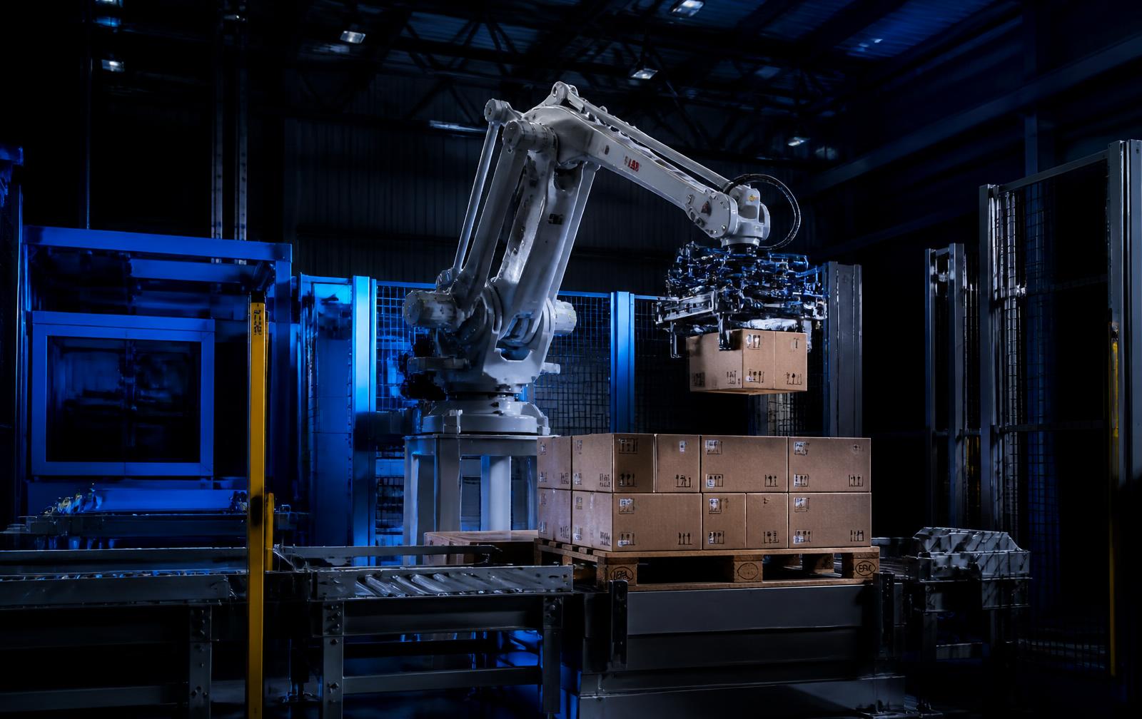 Kompakter Palettierroboter beim automatischen Stapeln von Kartons auf eine Palette
